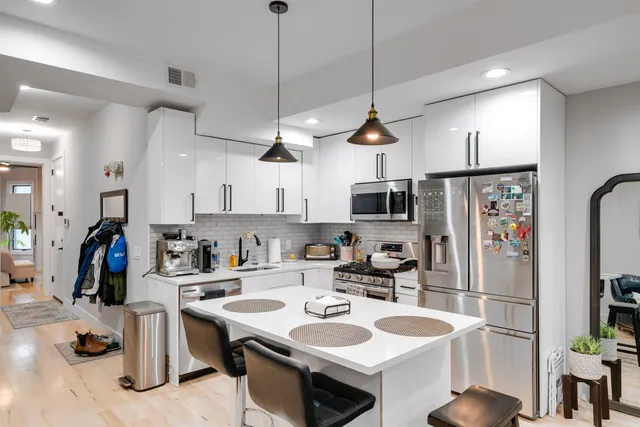 a kitchen with stainless steel appliances granite countertop a sink a stove and a refrigerator