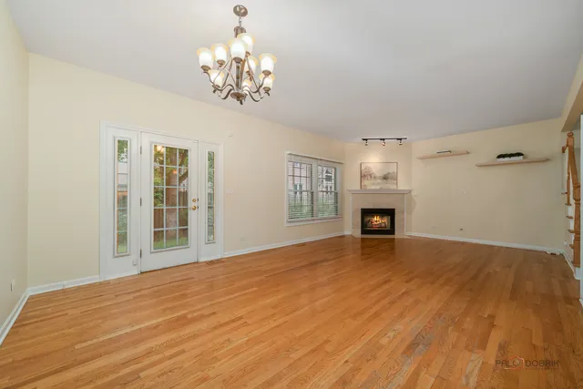 a view of empty room with wooden floor and fireplace