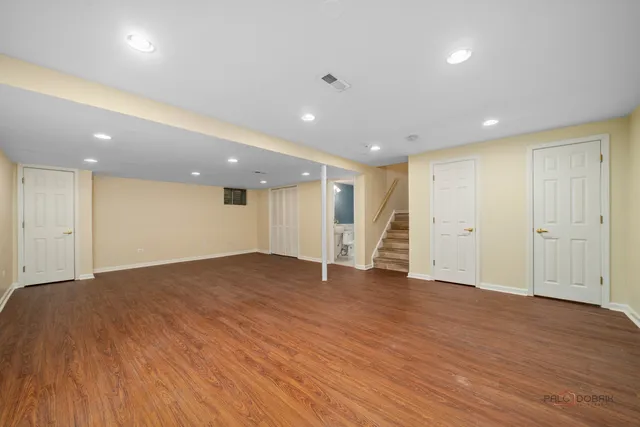 a view of an empty room with wooden floor