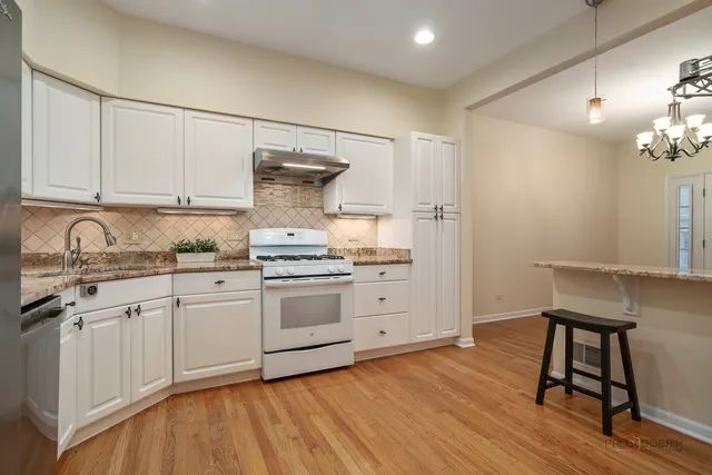 a kitchen with granite countertop a sink cabinets and wooden floor