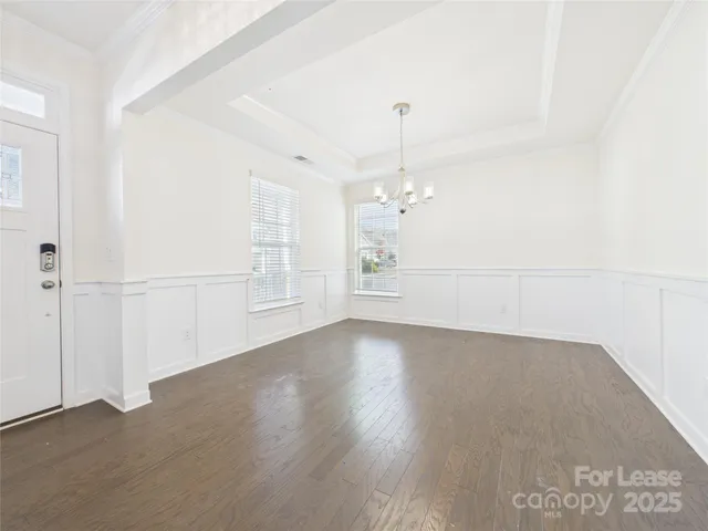 an empty room with wooden floor and door