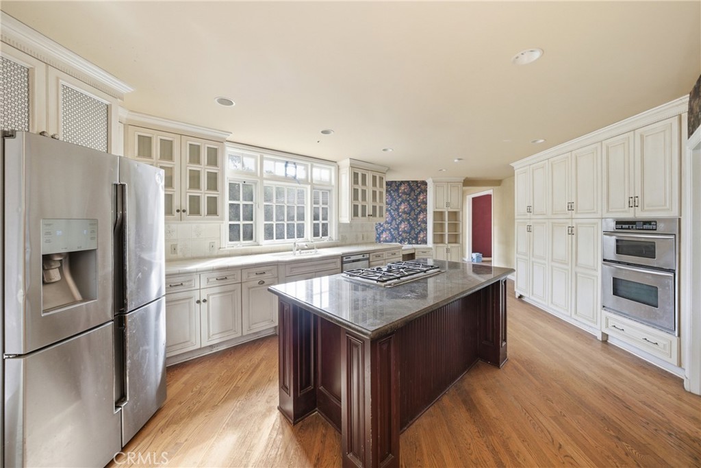 1210 Rodeo Road Arcadia, CA 91006 - Photo 10 of 45 a kitchen with stainless steel appliances granite countertop a stove a refrigerator and a sink with wooden cabinets