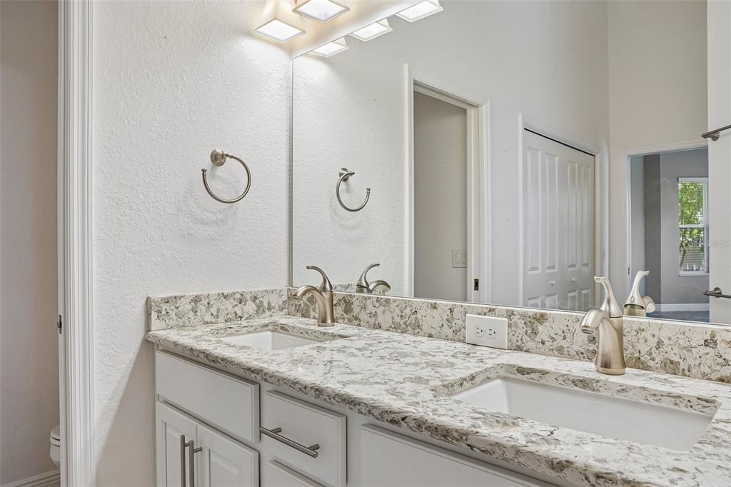 10339 Addison Shore Way Oxford, FL 34484 - Photo 41 of 54 a bathroom with a granite countertop sink and a mirror