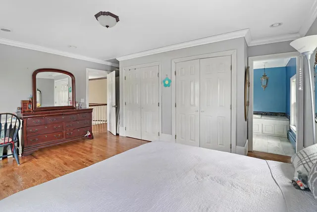 a spacious bedroom with a bed and a dresser