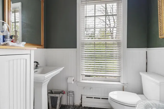 a bathroom with a sink a toilet and a window