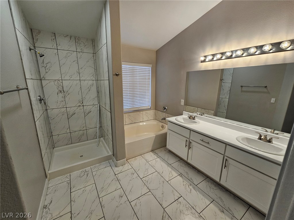 1418 Reebok Terrace Henderson, NV 89014 - Photo 20 of 39 A well-appointed bath features a tiled walk-in shower and a spacious dual-sink vanity.