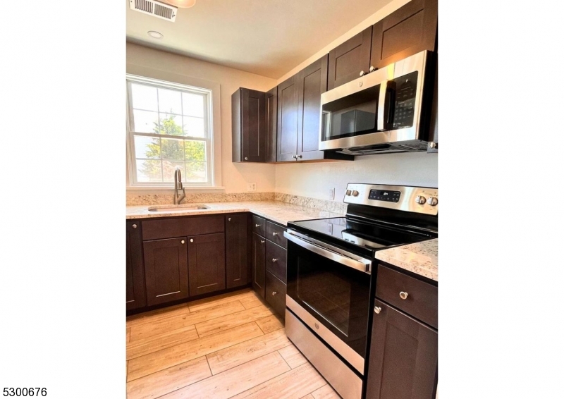 1 North Main Street, Unit 2 Stockton, NJ 08559 - Photo 7 of 12 a kitchen with stainless steel appliances a sink dishwasher stove microwave and cabinets