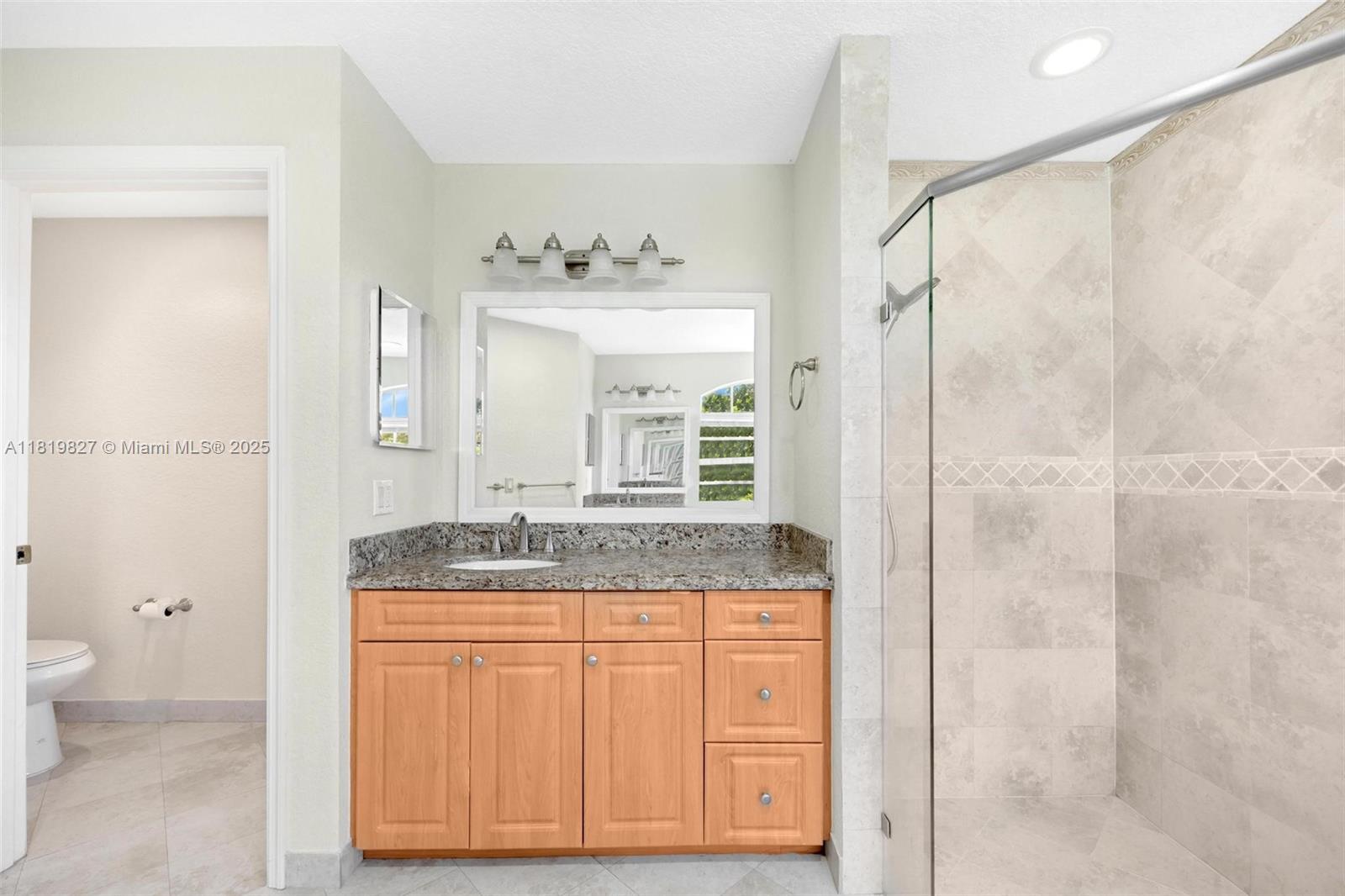 12851 Luray Road Southwest Ranches, FL 33330 - Photo 17 of 58 a bathroom with a granite countertop sink a toilet and a shower
