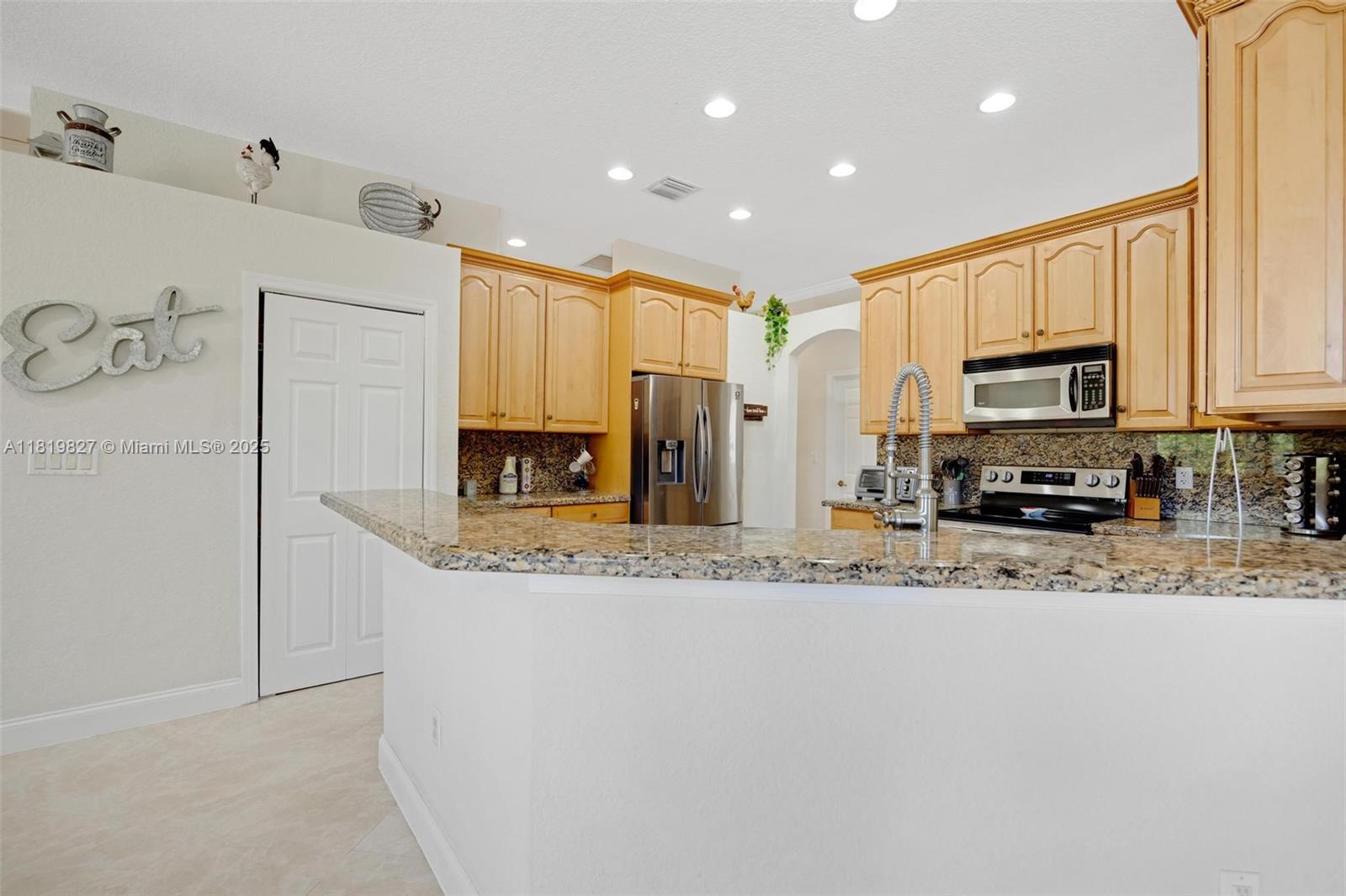 12851 Luray Road Southwest Ranches, FL 33330 - Photo 7 of 58 a view of a kitchen with stainless steel appliances granite countertop a stove a sink a refrigerator a microwave and cabinets