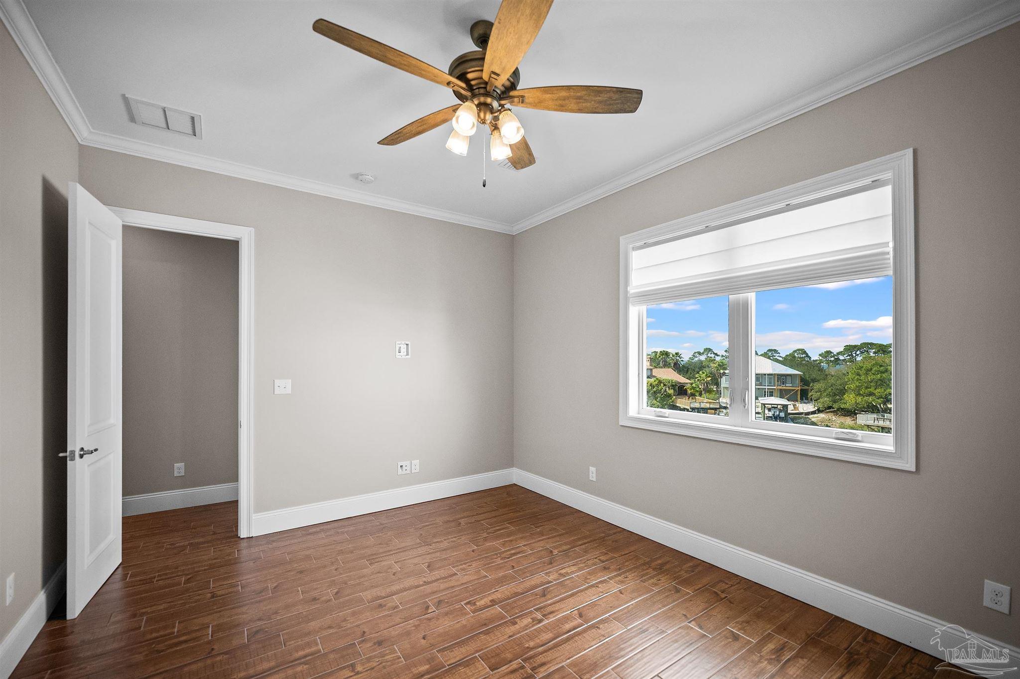 31729 River Road Orange Beach, AL 36561 - Photo 18 of 57 an empty room with wooden floor and windows