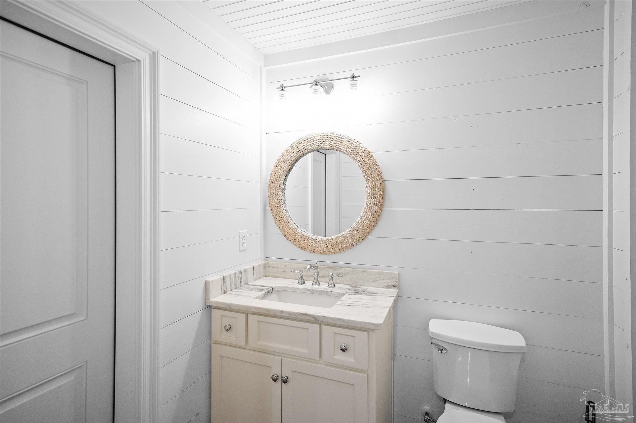 31729 River Road Orange Beach, AL 36561 - Photo 22 of 57 a bathroom with a toilet a sink and a mirror