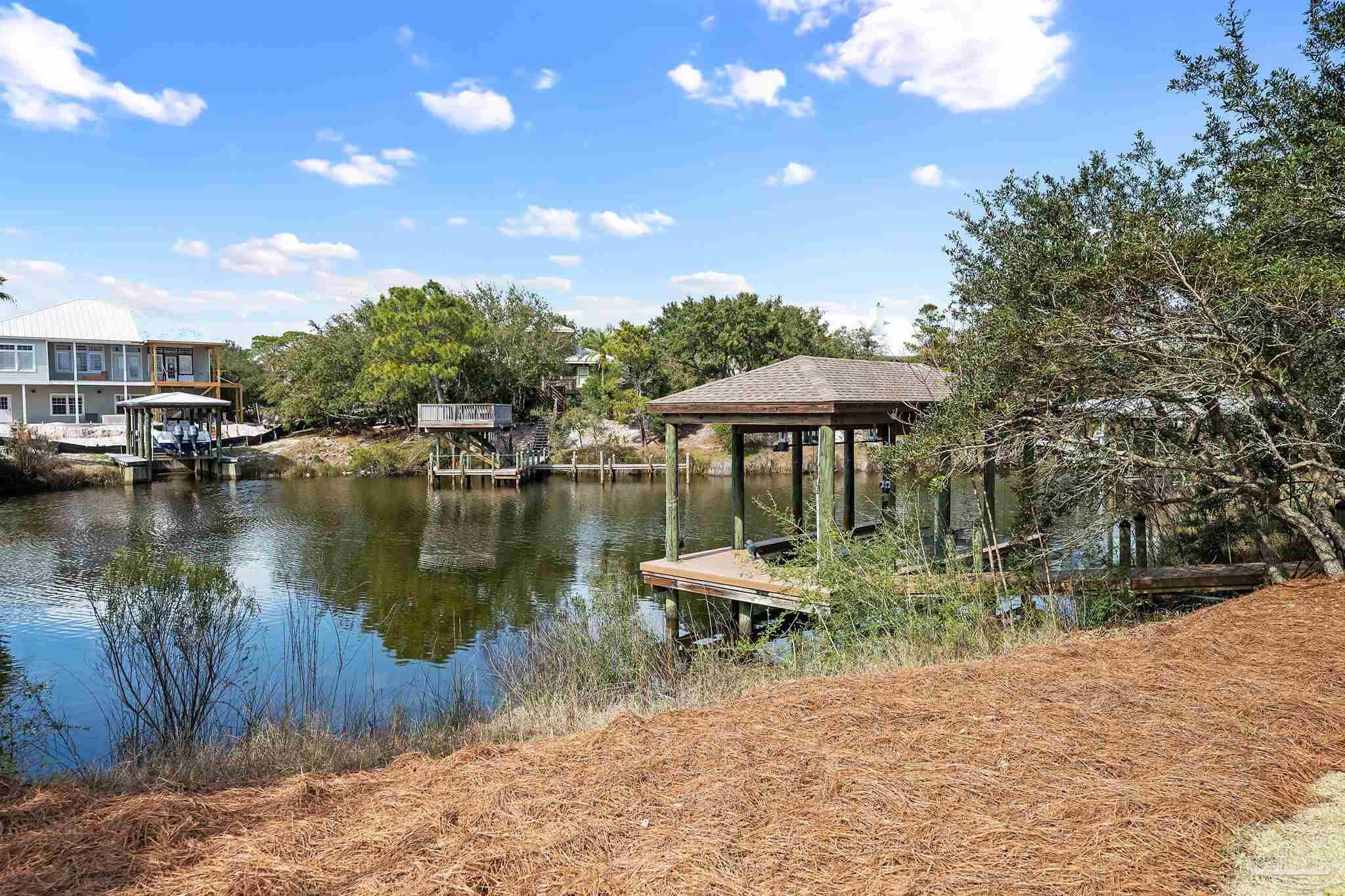 31729 River Road Orange Beach, AL 36561 - Photo 41 of 57 a view of a lake with a table and chairs under an umbrella