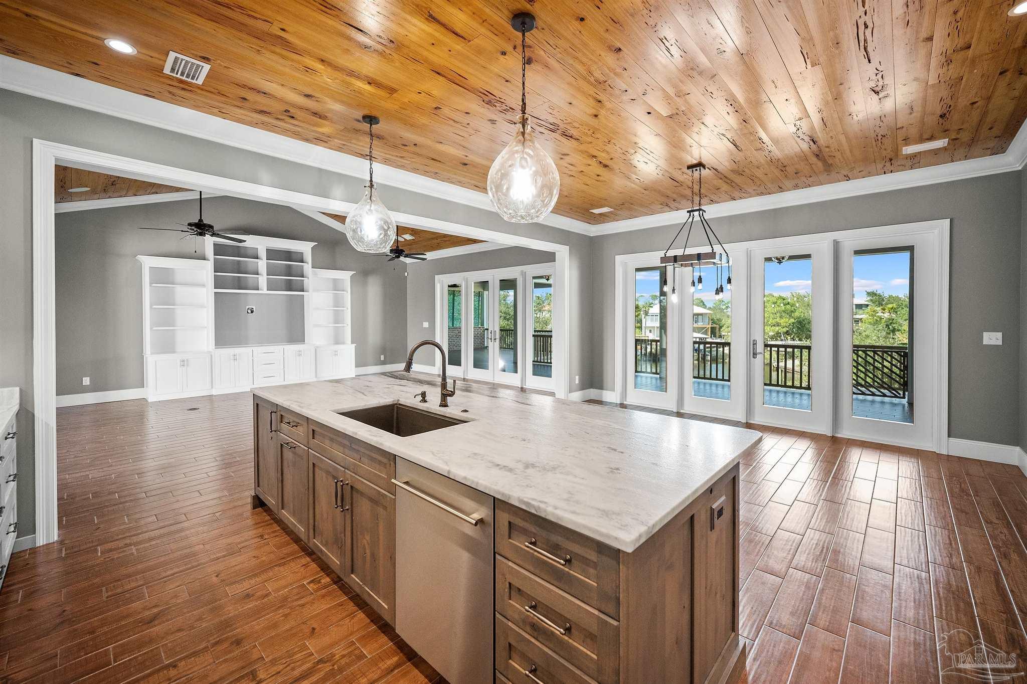 31729 River Road Orange Beach, AL 36561 - Photo 6 of 57 a kitchen with stainless steel appliances granite countertop a sink a oven and wooden floors