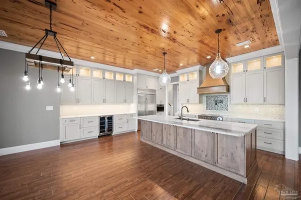 an empty room with wooden floor ceiling fan and windows