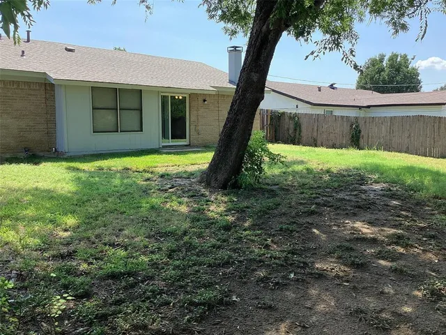 a view of a backyard with a garden and tree