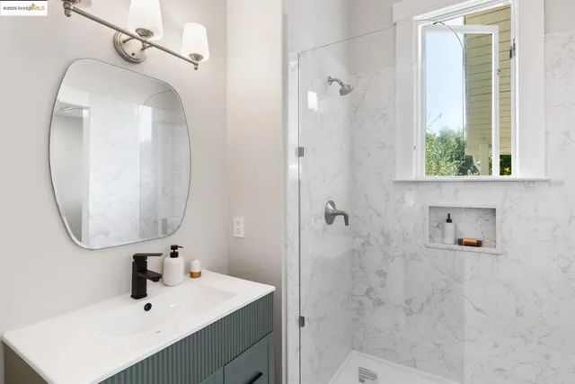 a bathroom with a sink a mirror and shower
