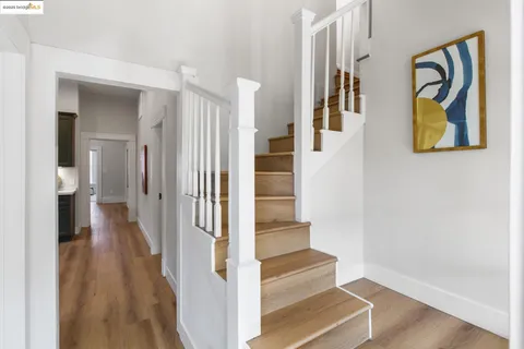 a view of a hallway with wooden floor and entryway
