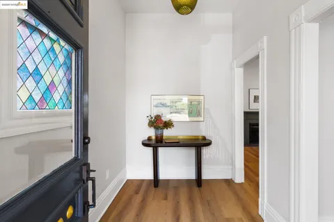 a view of a hallway with wooden floor and furniture