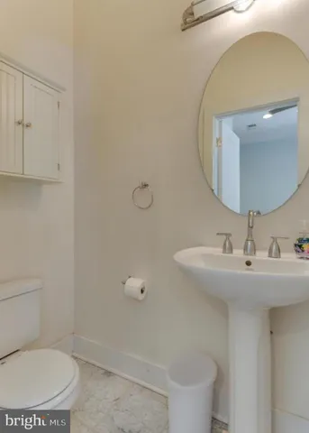 a bathroom with a sink a toilet and a mirror