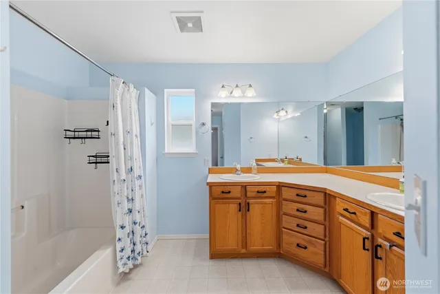 a spacious bathroom with a granite countertop sink a mirror a shower and a bathtub