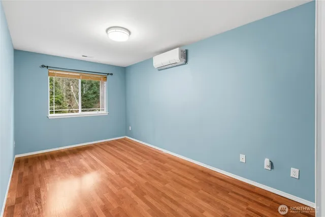 a view of a big room with wooden floor and windows
