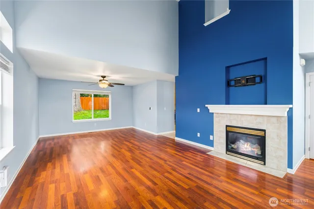 a view of empty room with a fireplace and wooden floor