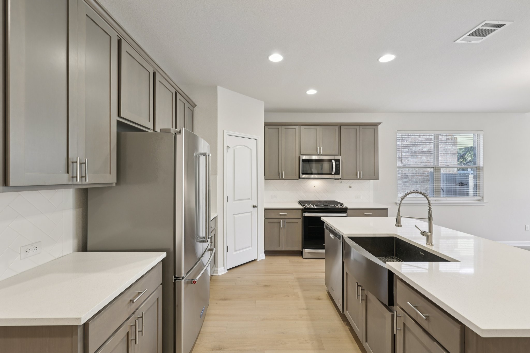 308 Castlefields Street Hutto, TX 78634 - Photo 12 of 31 a kitchen with stainless steel appliances granite countertop a sink stove and refrigerator