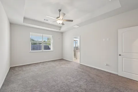 an empty room with windows and fan
