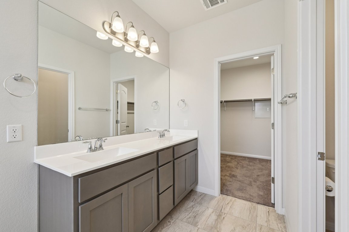 308 Castlefields Street Hutto, TX 78634 - Photo 18 of 31 a bathroom with a sink double vanity and a mirror