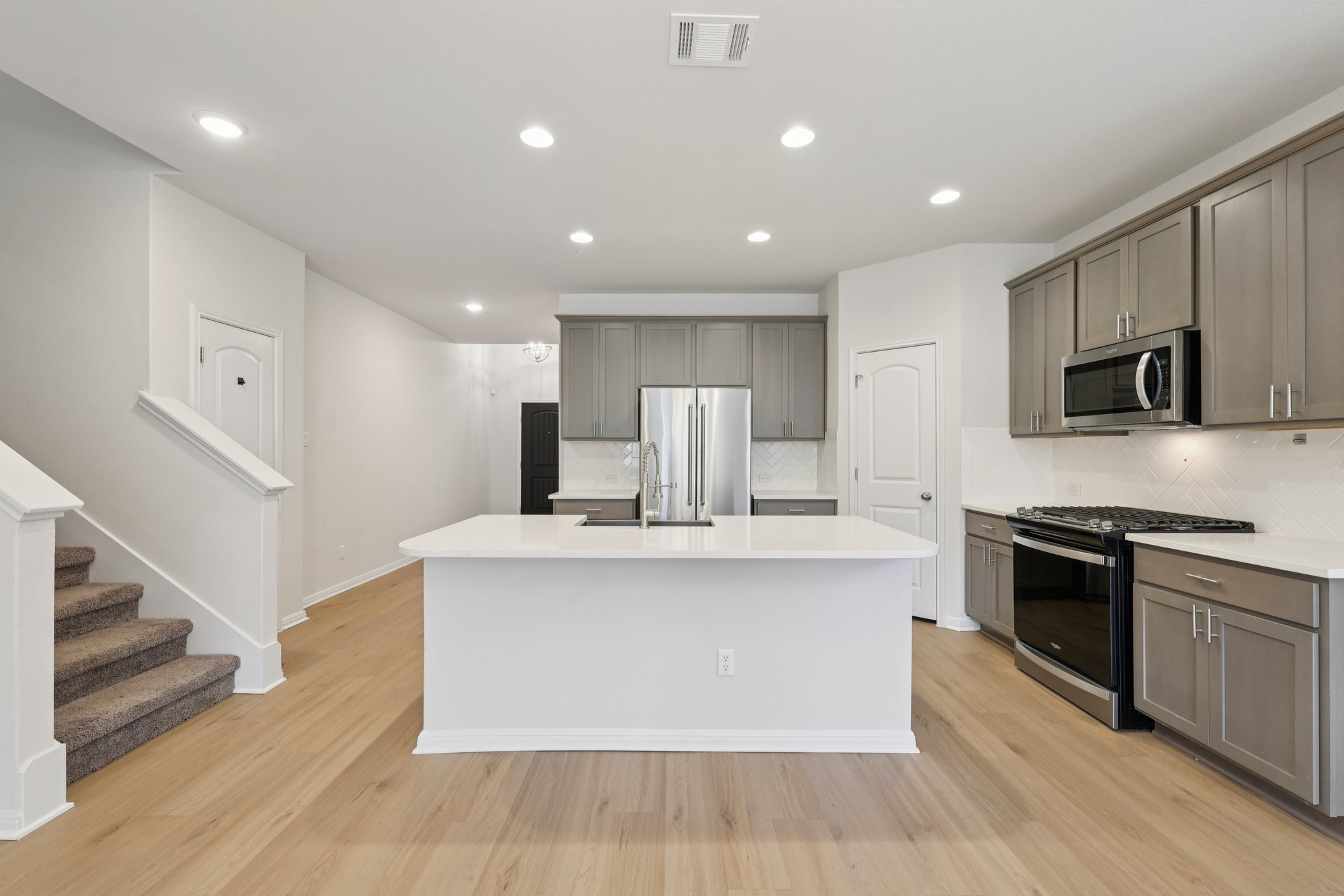 308 Castlefields Street Hutto, TX 78634 - Photo 2 of 31 a large kitchen with stainless steel appliances granite countertop a stove and a sink