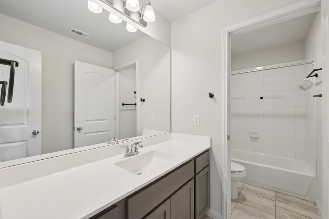 308 Castlefields Street Hutto, TX 78634 - Photo 24 of 31 a bathroom with a sink a toilet and shower