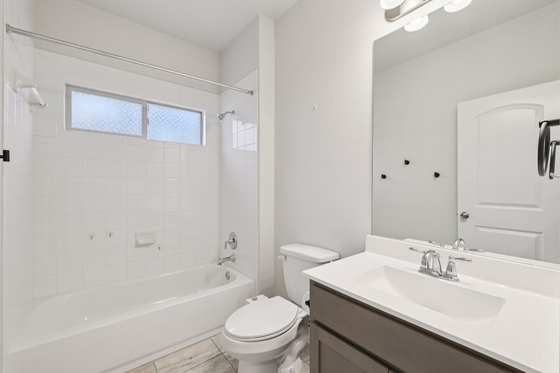308 Castlefields Street Hutto, TX 78634 - Photo 10 of 31 a bathroom with a sink a toilet and shower