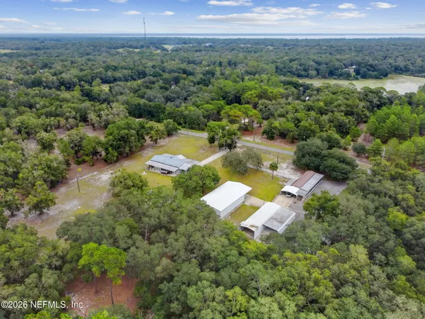 a aerial view of a house with a yard and lake view