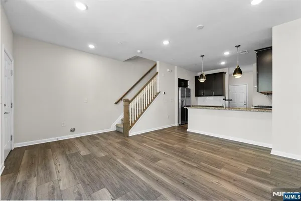 a view of empty room with wooden floor and stairs