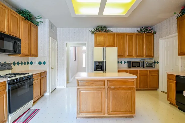 a kitchen with stainless steel appliances granite countertop a stove a sink and a refrigerator