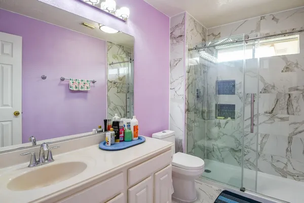 a bathroom with a sink vanity granite and toilet