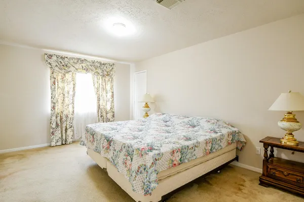 a bedroom with a bed table and a window