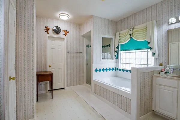 a hallway with painting on the wall and a window