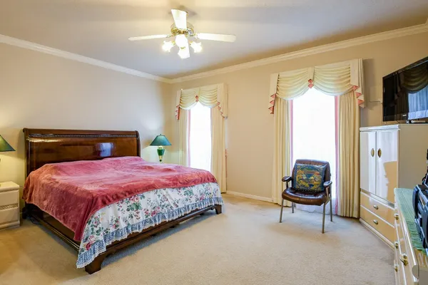 a bedroom with a bed dresser and a flat tv screen
