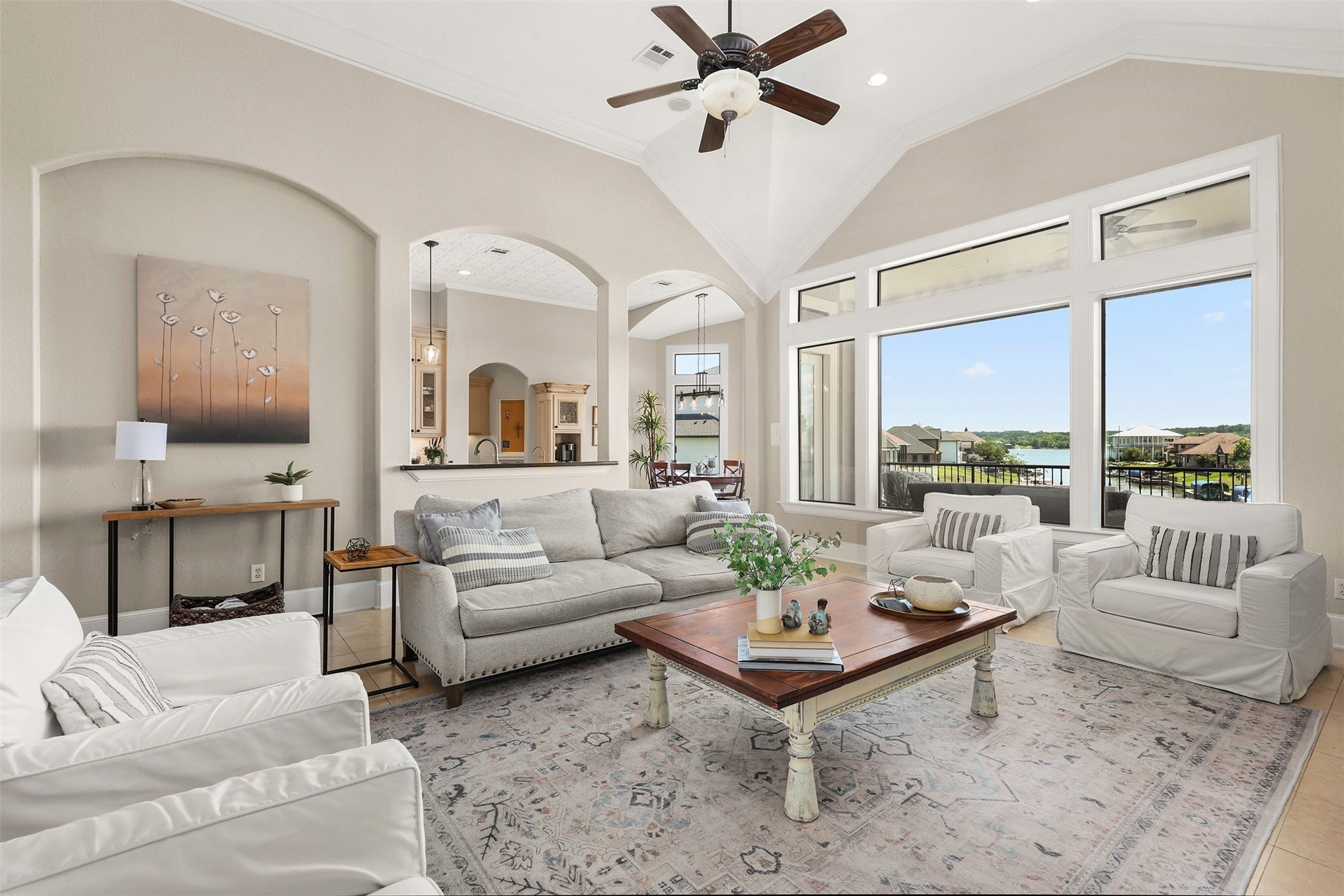 10896 Decatur Street Willis, TX 77318 - Photo 23 of 50 This spacious living room boasts high ceilings and large windows that flood the space with natural light, offering scenic water views and a cozy seating area in a neutral palette for an inviting, open atmosphere.