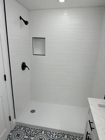 a bathroom with a bathtub shower sink vanity and toilet