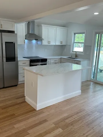 a kitchen with stainless steel appliances granite countertop a stove a sink and a refrigerator
