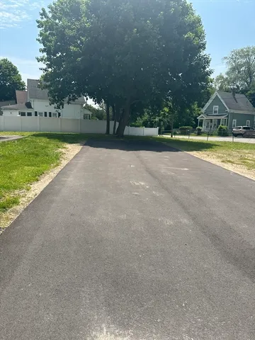 a view of a house with a big yard and large trees