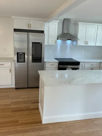 a kitchen with kitchen island a stove a sink and a refrigerator