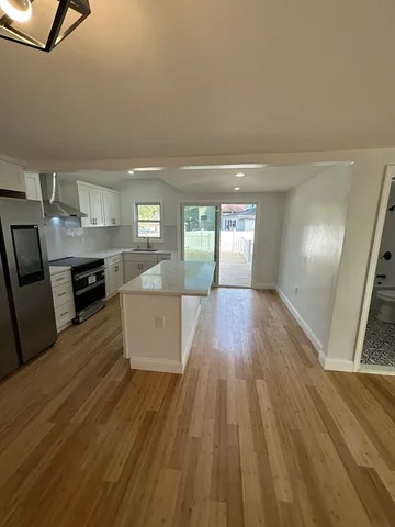 a view of a kitchen with a dishwasher and wooden floor