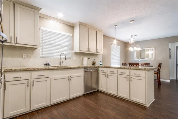 a kitchen with granite countertop white cabinets and white appliances