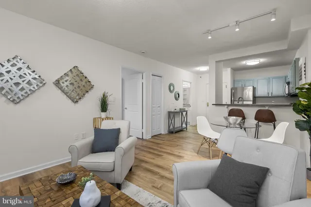 a living room with furniture and a dining table with wooden floor