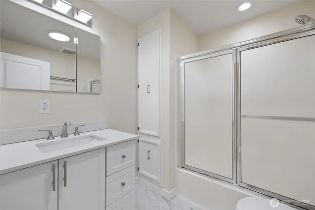 a bathroom with a shower sink vanity and mirror