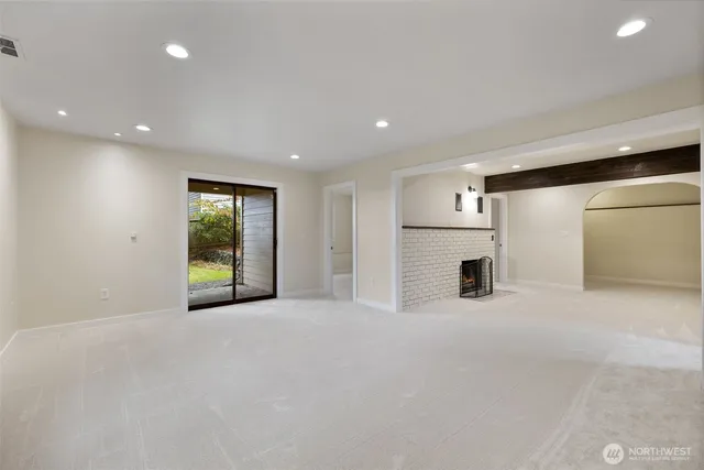 a view of an empty room with a fireplace and a window