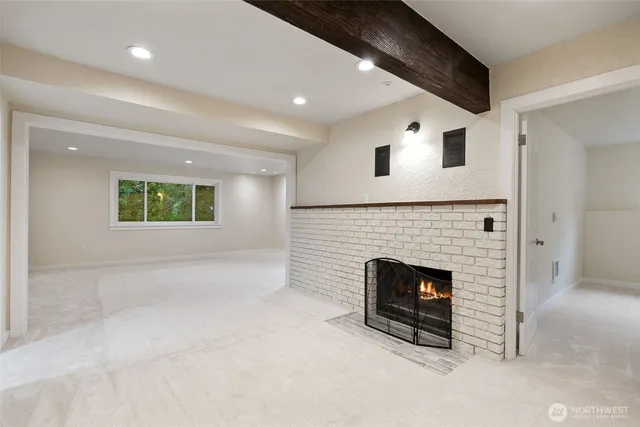 an empty room with windows and fireplace